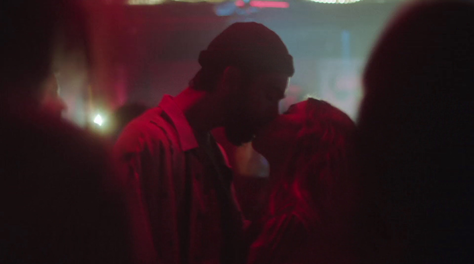 a man and a woman kissing in a dark room