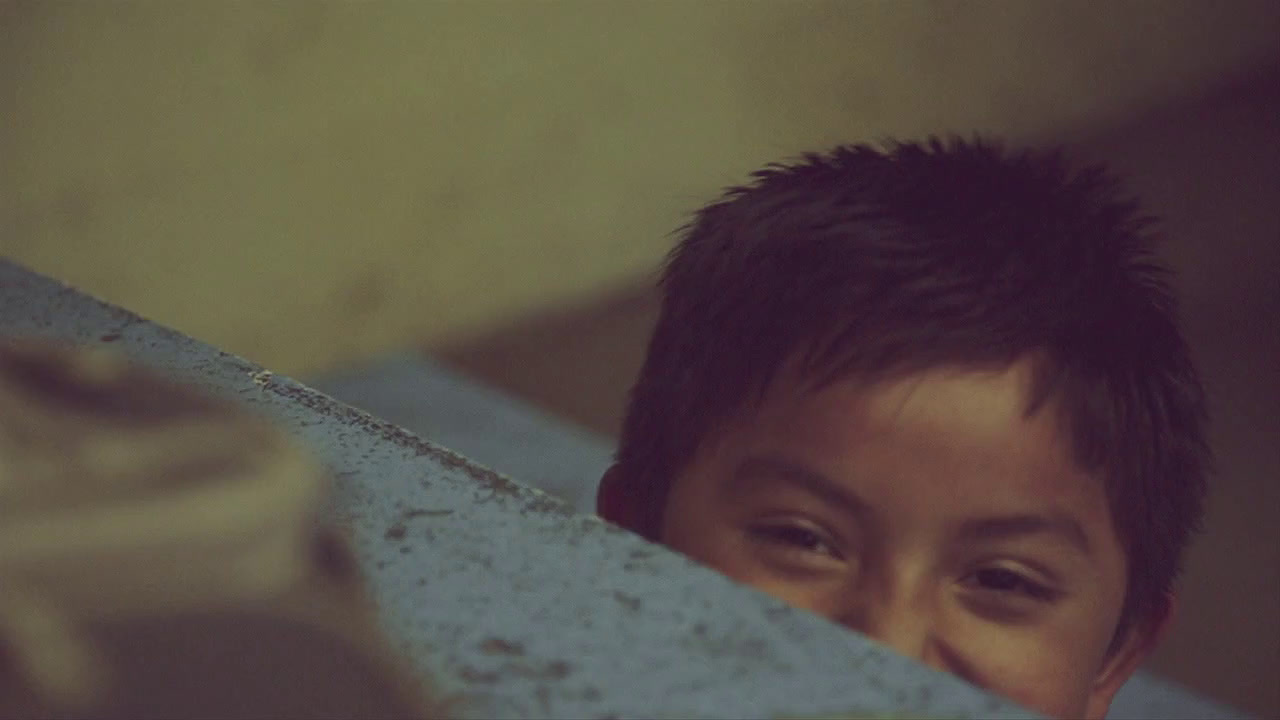 a young boy peeking over the edge of a wall