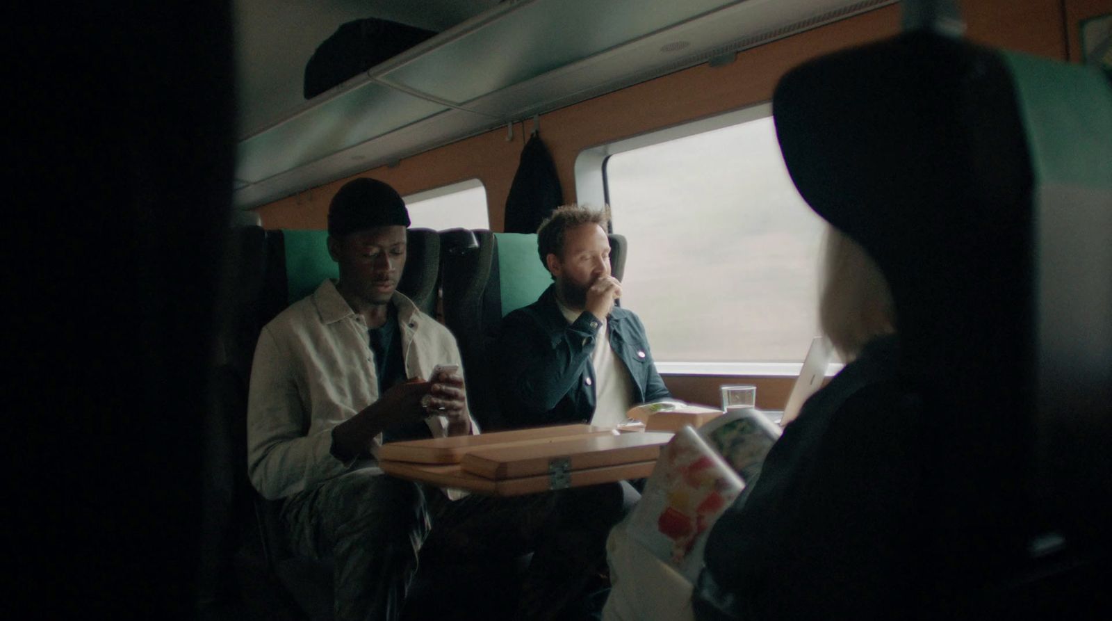 a group of people sitting on a train next to each other