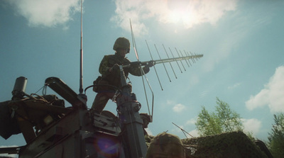 a man standing on top of a truck holding a radio antenna