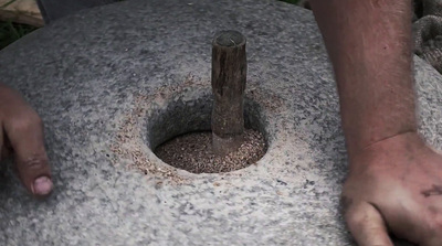 a man holding a stone with a wooden stick sticking out of it