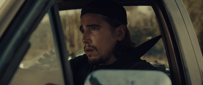 a man sitting in a car looking out the window