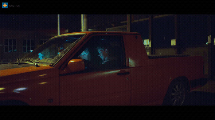 a red truck with two people in it at night