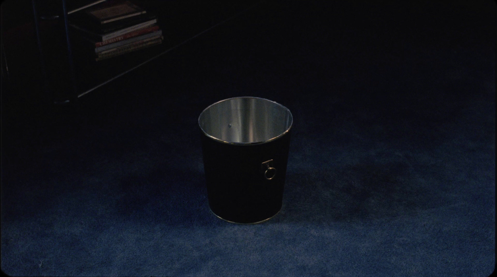 a black trash can sitting on a blue floor