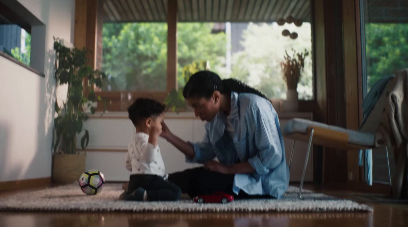 a man kneeling down next to a little boy