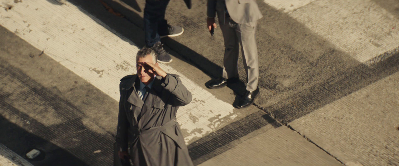 a man standing on the side of a road talking on a cell phone