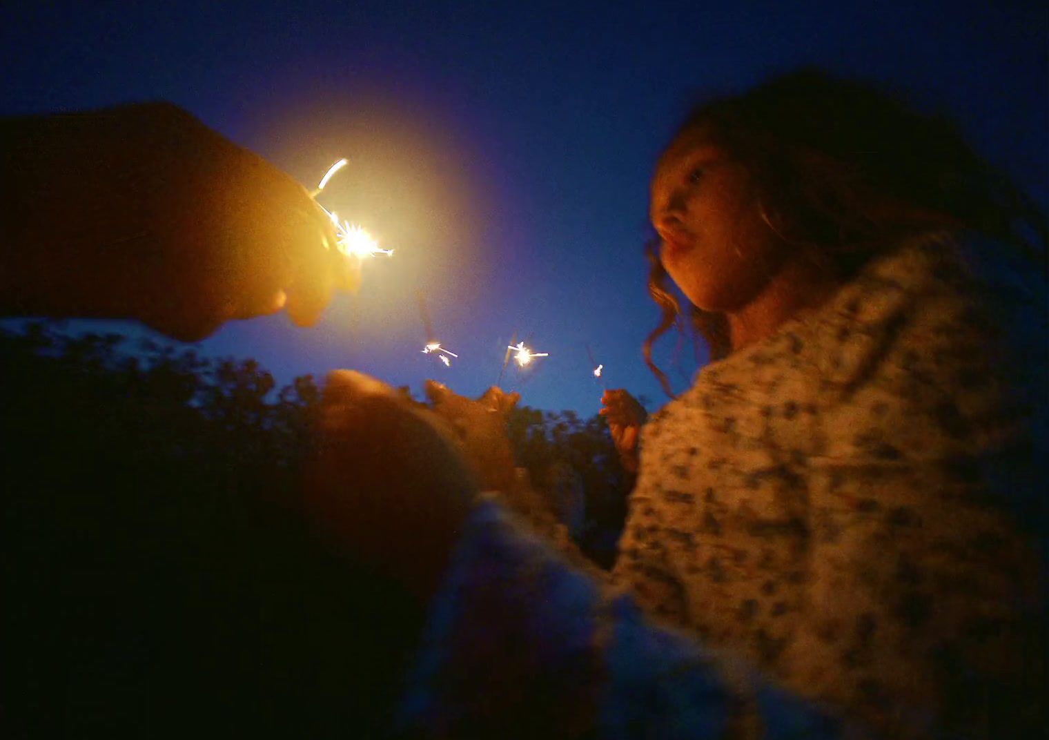 a young girl holding a sparkler in her hands