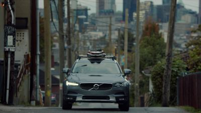 a car driving down a street with a city in the background