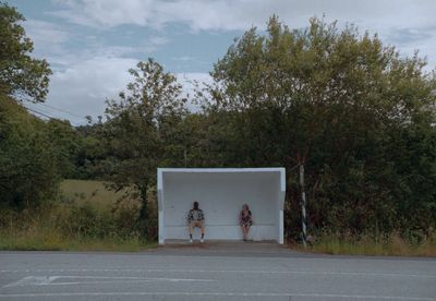 two women sitting in a white box on the side of the road