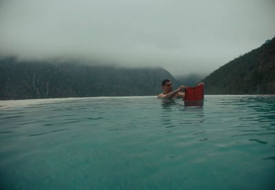 a man floating in a pool with a life jacket on