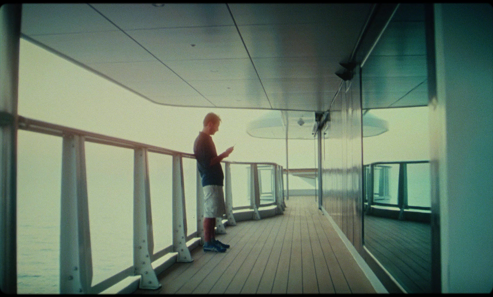 a man standing on a deck next to a railing