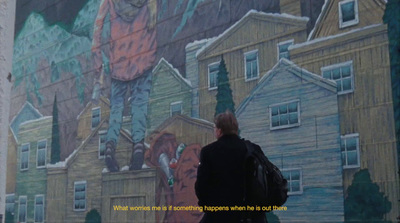 a man standing in front of a large mural