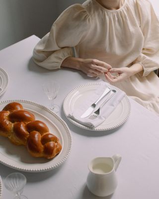 a woman sitting at a table with a plate of donuts