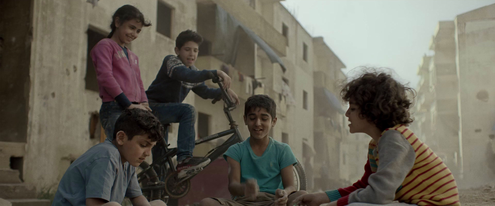 a group of people sitting on the ground near a building