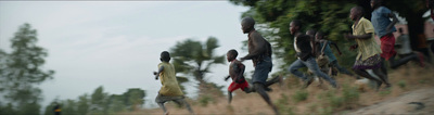 a group of people running down a dirt road