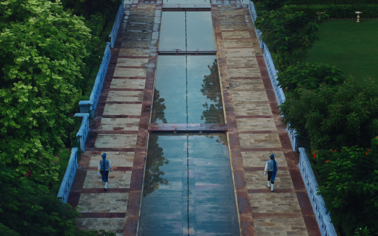 an aerial view of a pool surrounded by trees