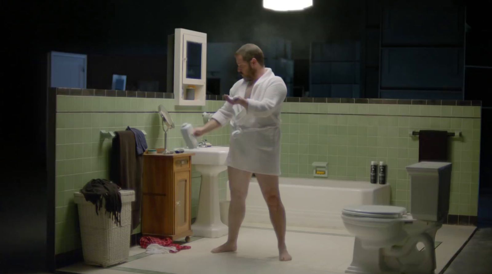 a man standing in a bathroom next to a sink