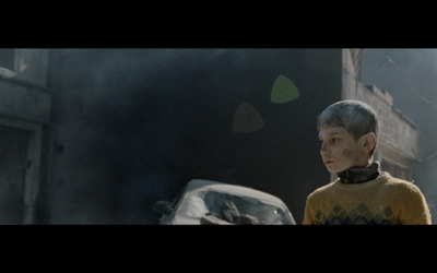 a young boy standing in front of a burning car