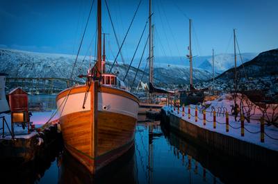 a boat docked in a harbor with snow on the ground