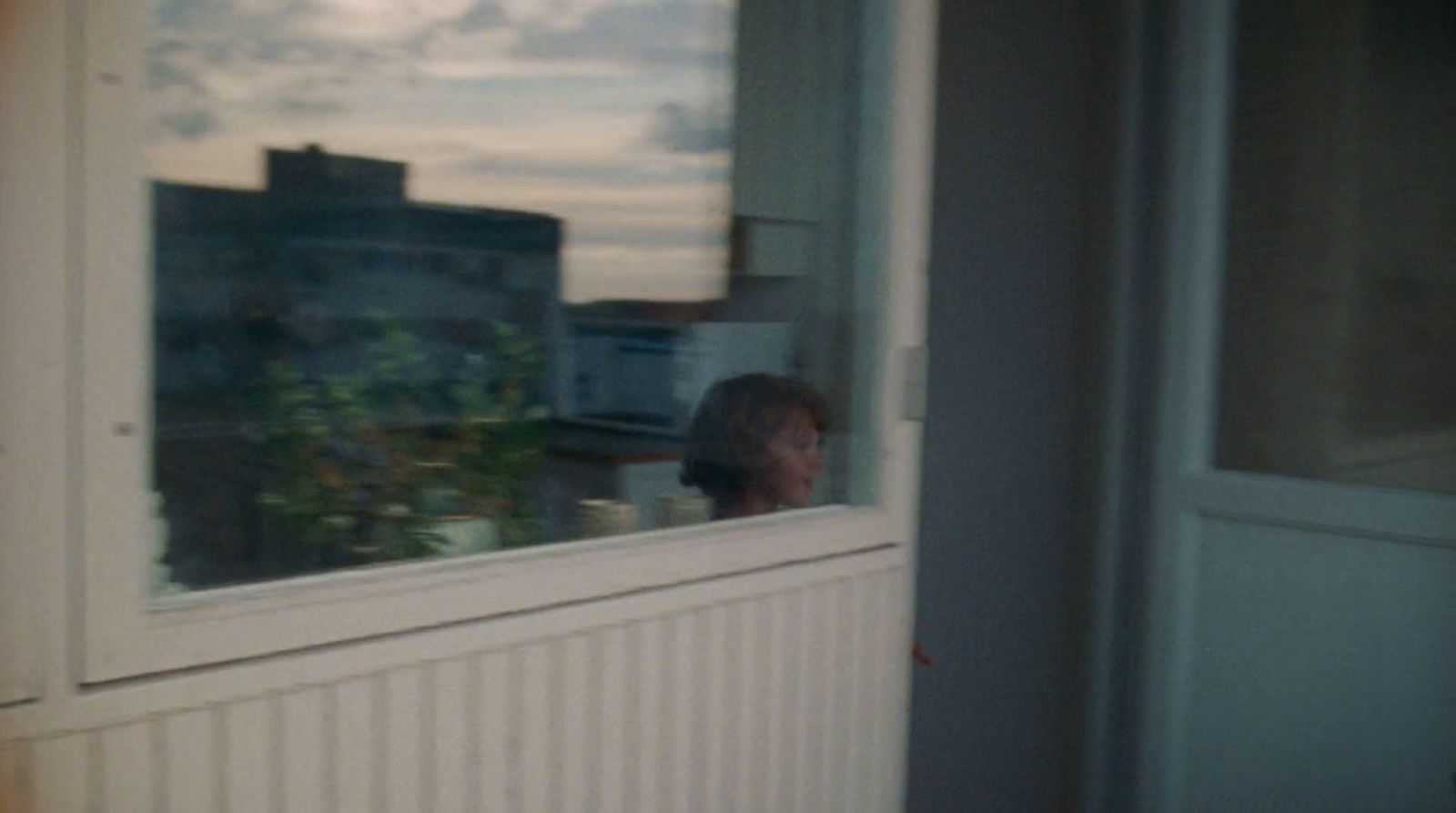 a woman looking out of a window at the sky