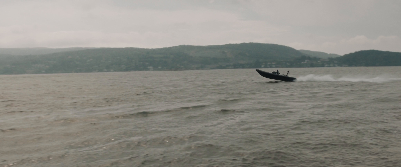 a boat in the water with mountains in the background