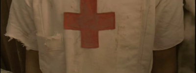 a man in a white shirt with a red cross on it