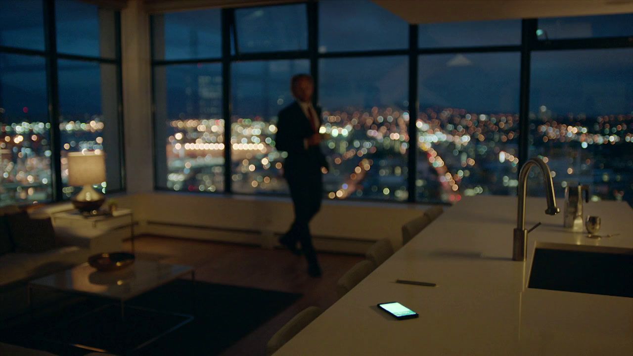 a man standing in a kitchen next to a window