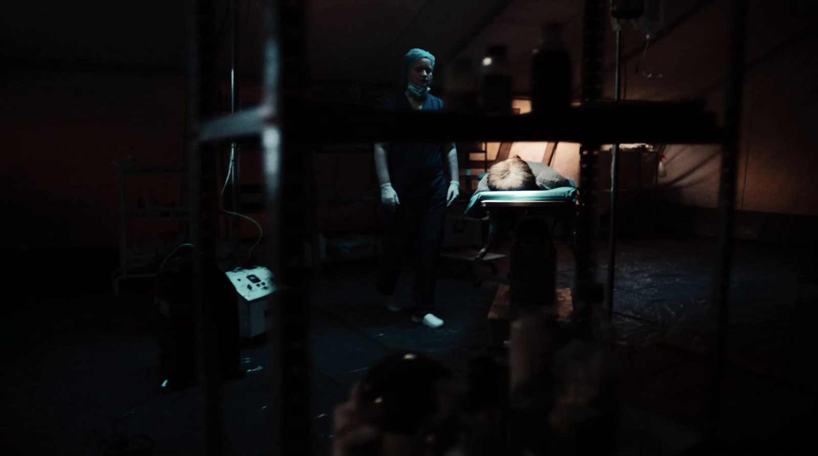 a man standing next to a bed in a dark room