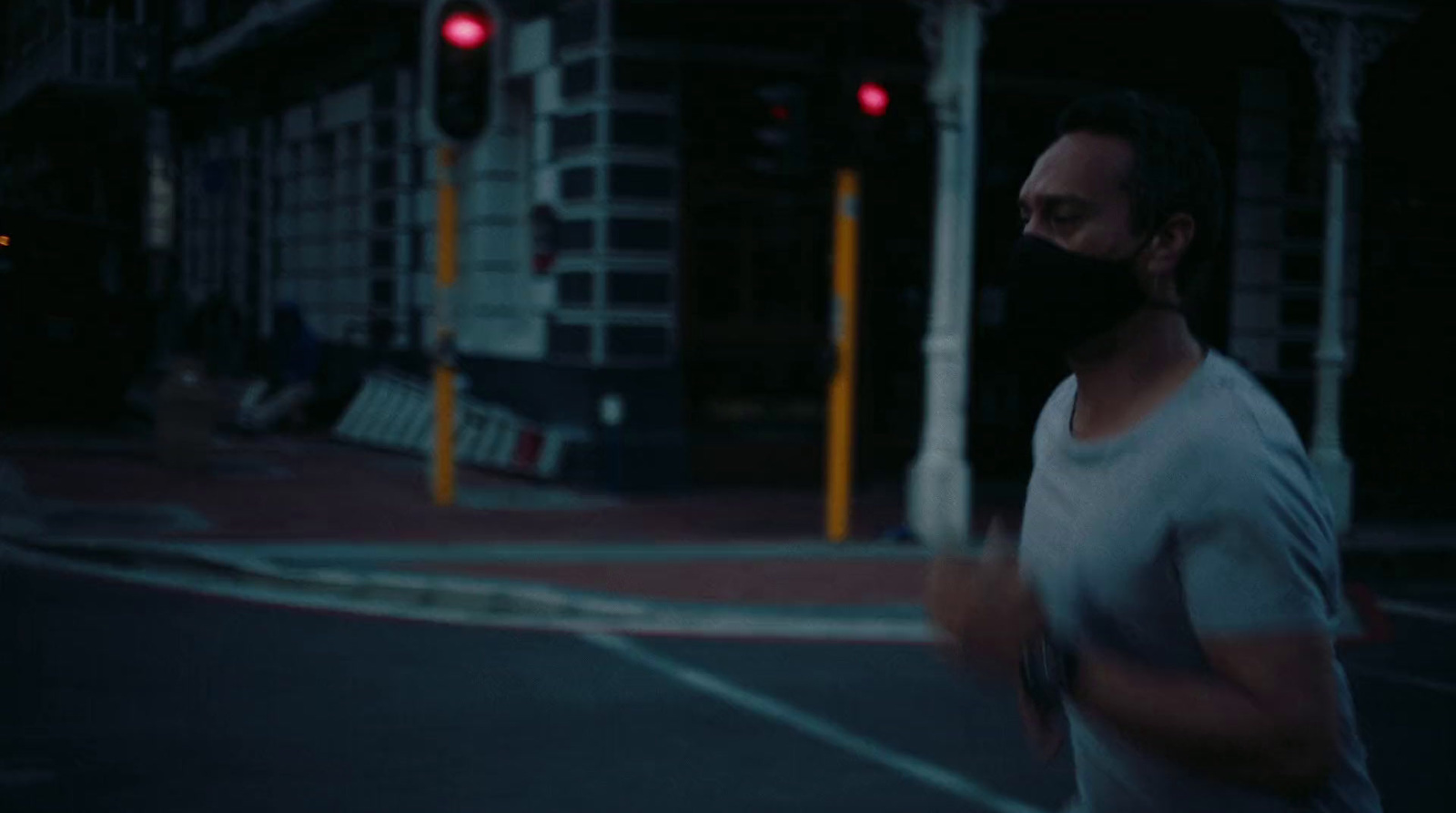 a man wearing a face mask crossing a street