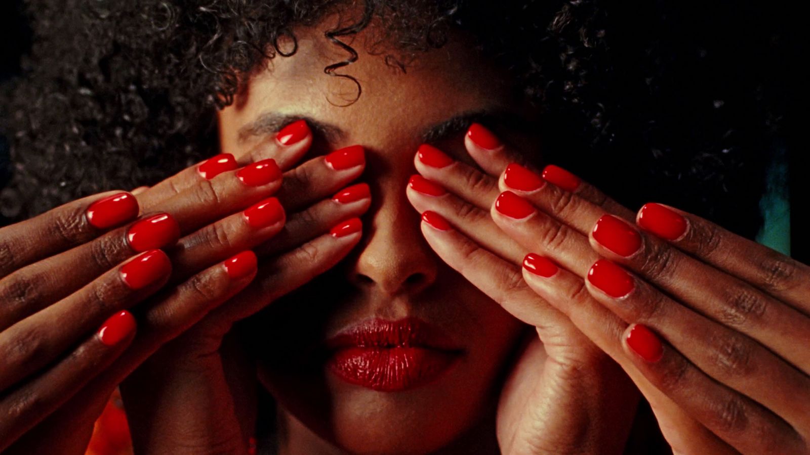 a woman with red nails covering her eyes