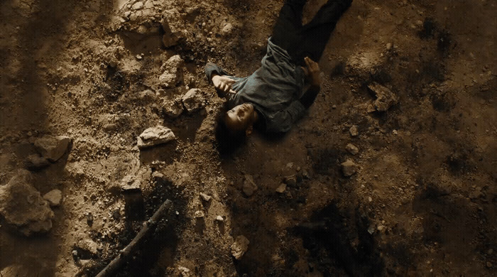 a man laying on the ground in the dirt