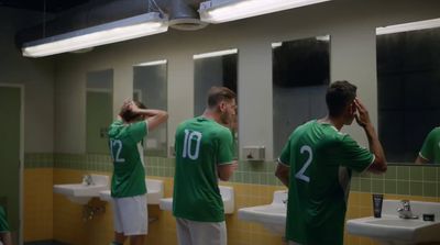 a group of men standing in front of a bathroom mirror