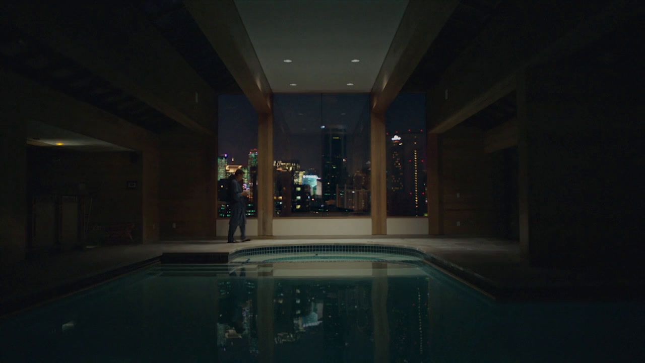 a man standing in the middle of a swimming pool at night