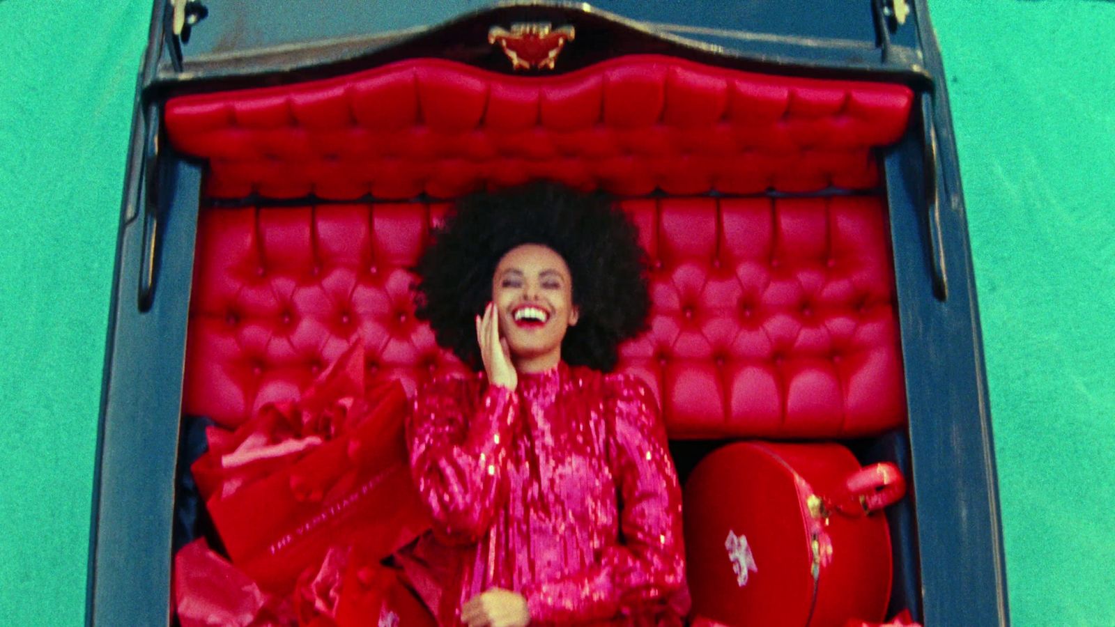 a woman in a red dress sitting in a red chair