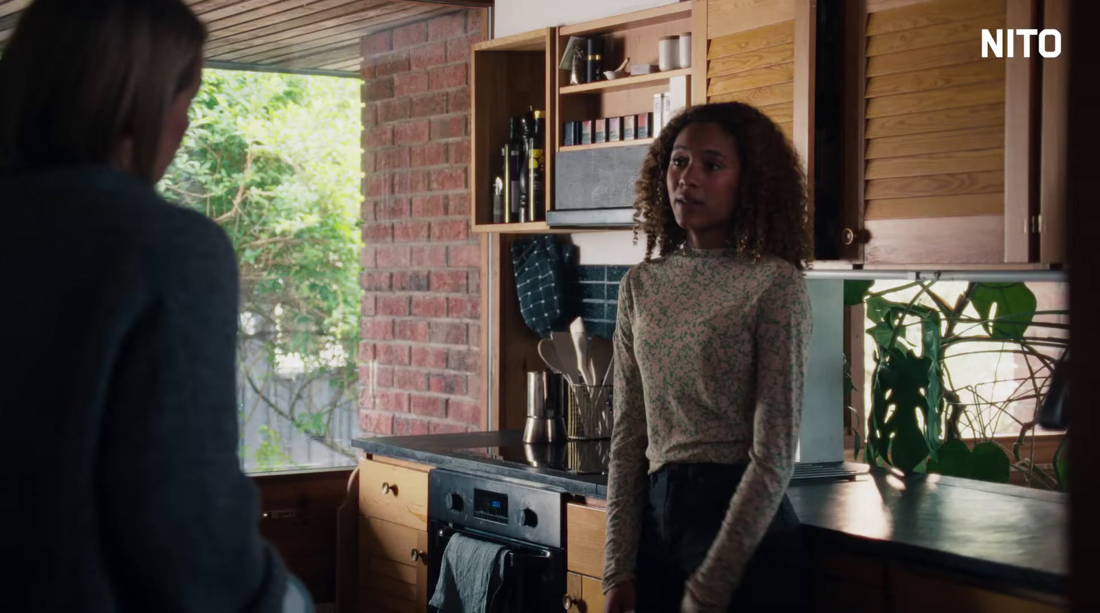 a woman standing in a kitchen next to a window