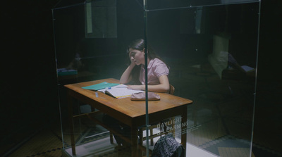 a woman sitting at a desk with a book in front of her