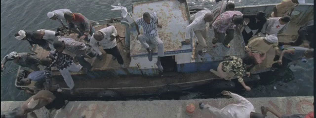 a group of people standing on top of a boat