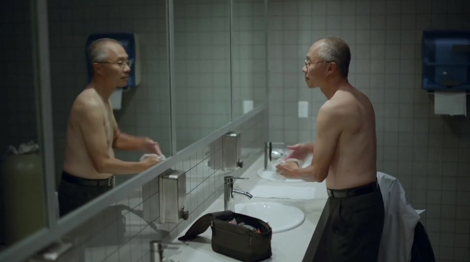 a man standing in front of a bathroom mirror