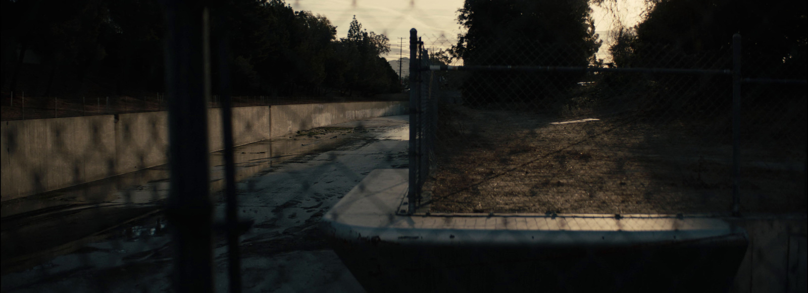 a fenced in area with a dirt path next to it