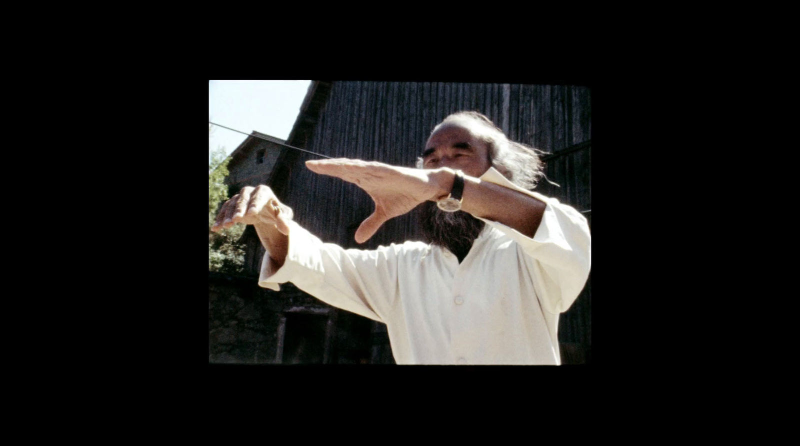 a man with long hair and a white shirt