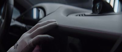 a gloved hand on the dashboard of a car