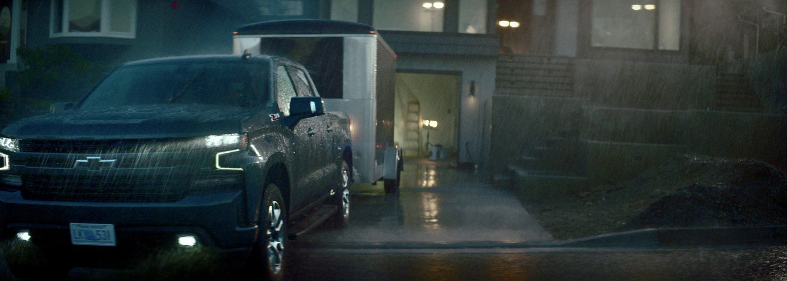 a truck parked in front of a house on a rainy night