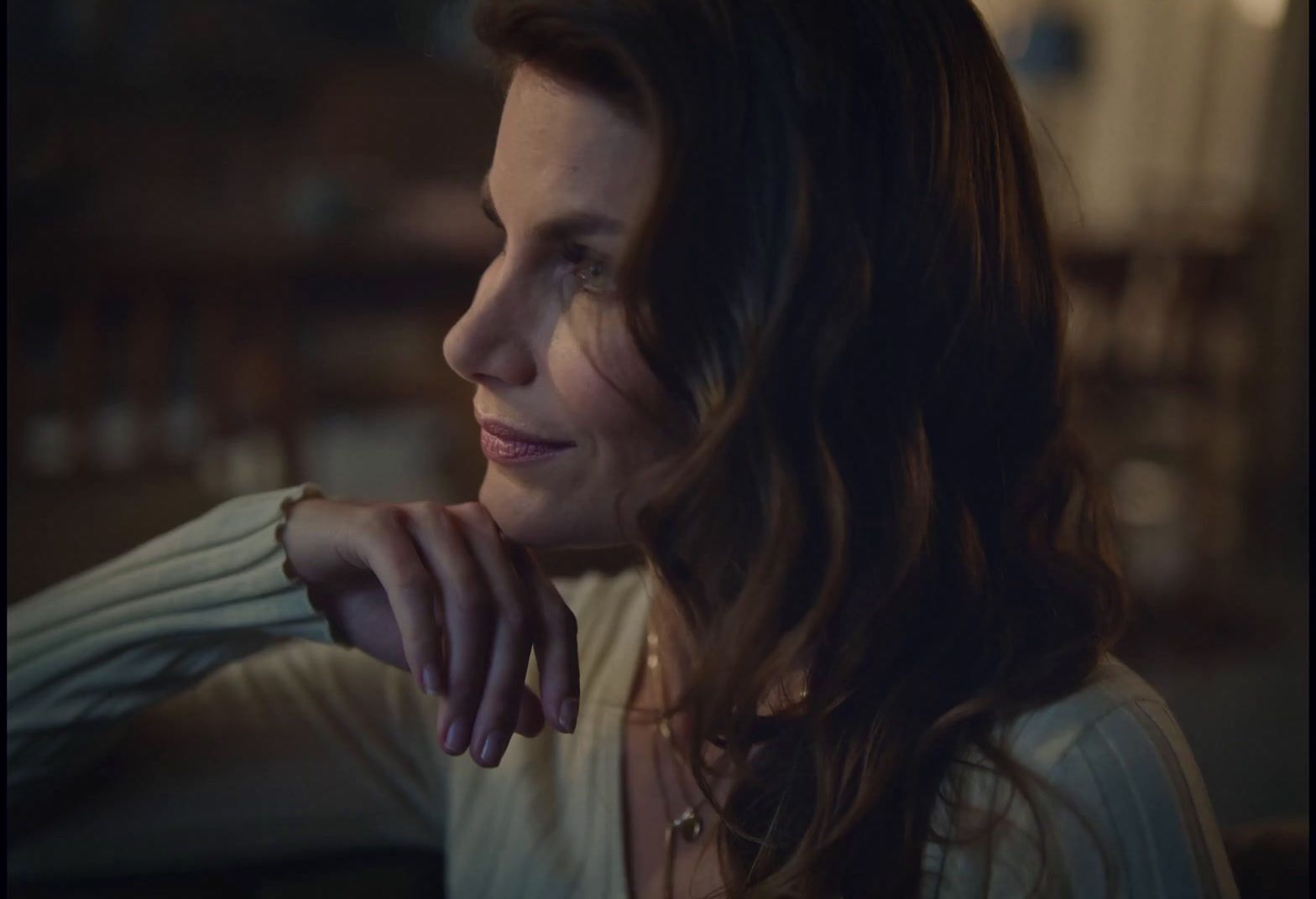 a woman with long brown hair and a white shirt