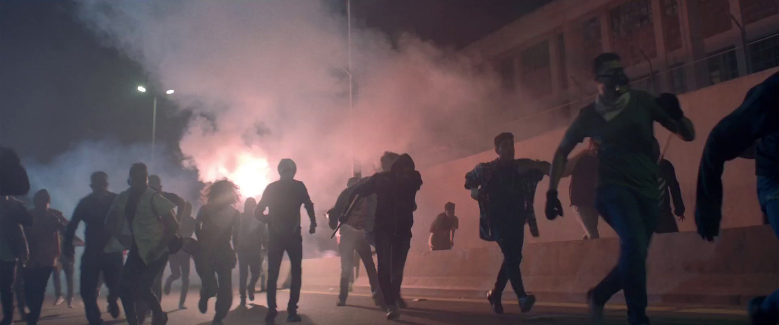 a group of people walking down a street at night