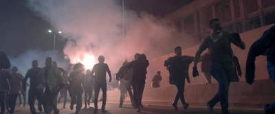 a group of people walking down a street at night