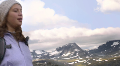 a woman standing on top of a snow covered mountain