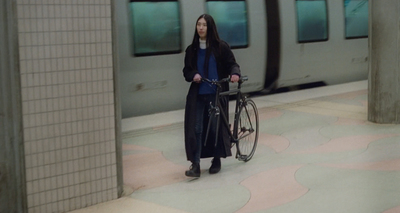 a woman holding a bike in a subway station