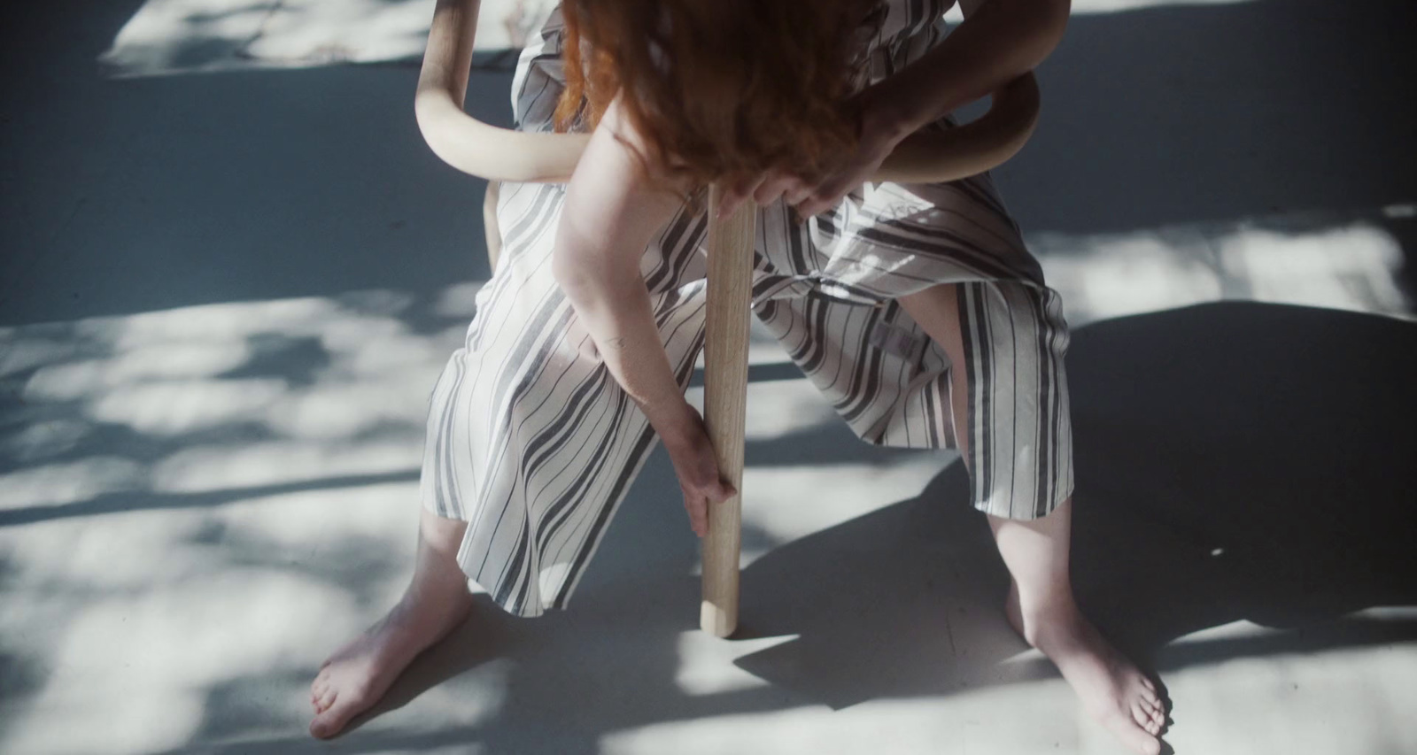 a woman sitting on a chair holding a baseball bat