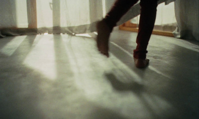 a person walking across a white floor next to a window