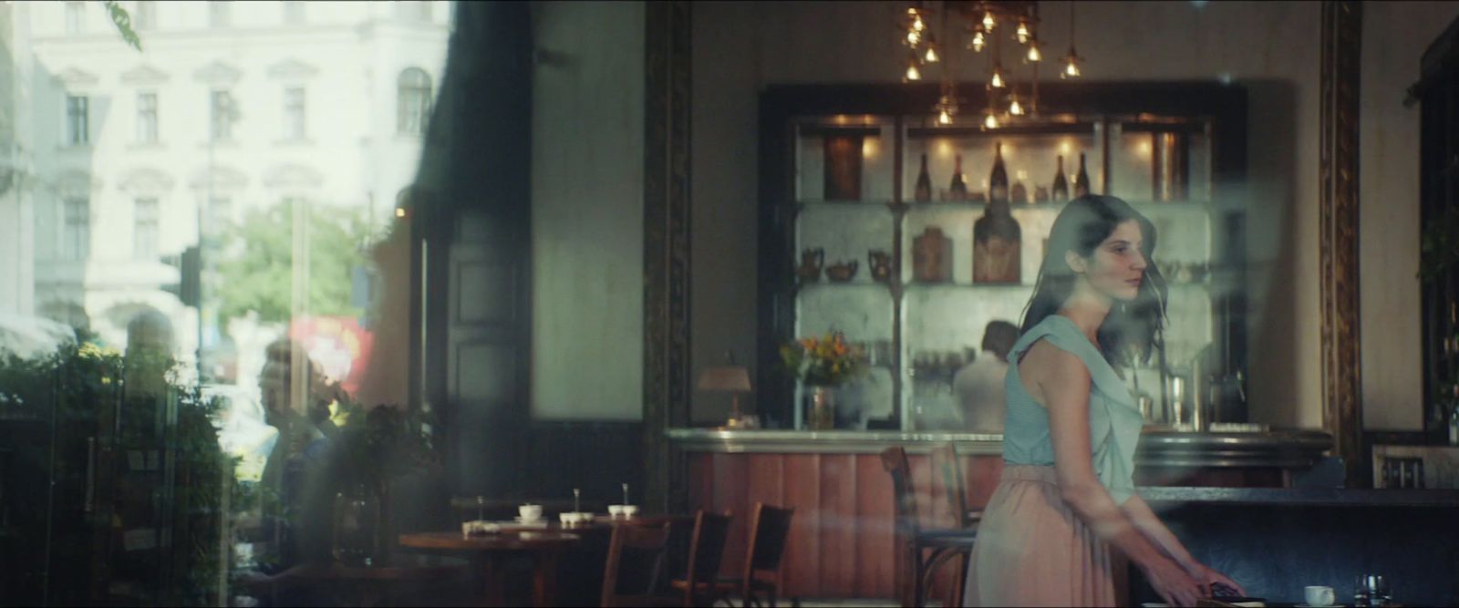 a woman walking down a street past a bar